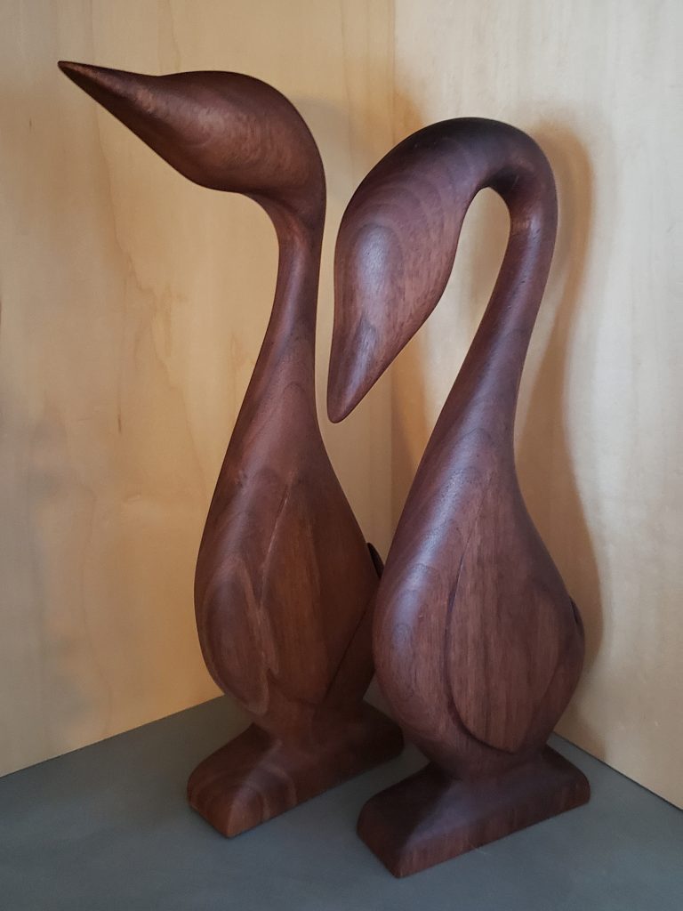 Two walnut wood geese with maple background