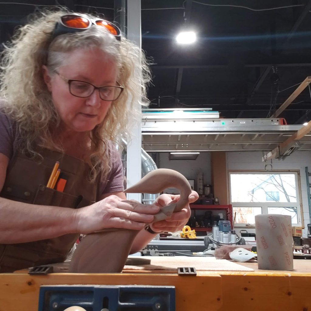 Kim sanding wooden goose while in vise